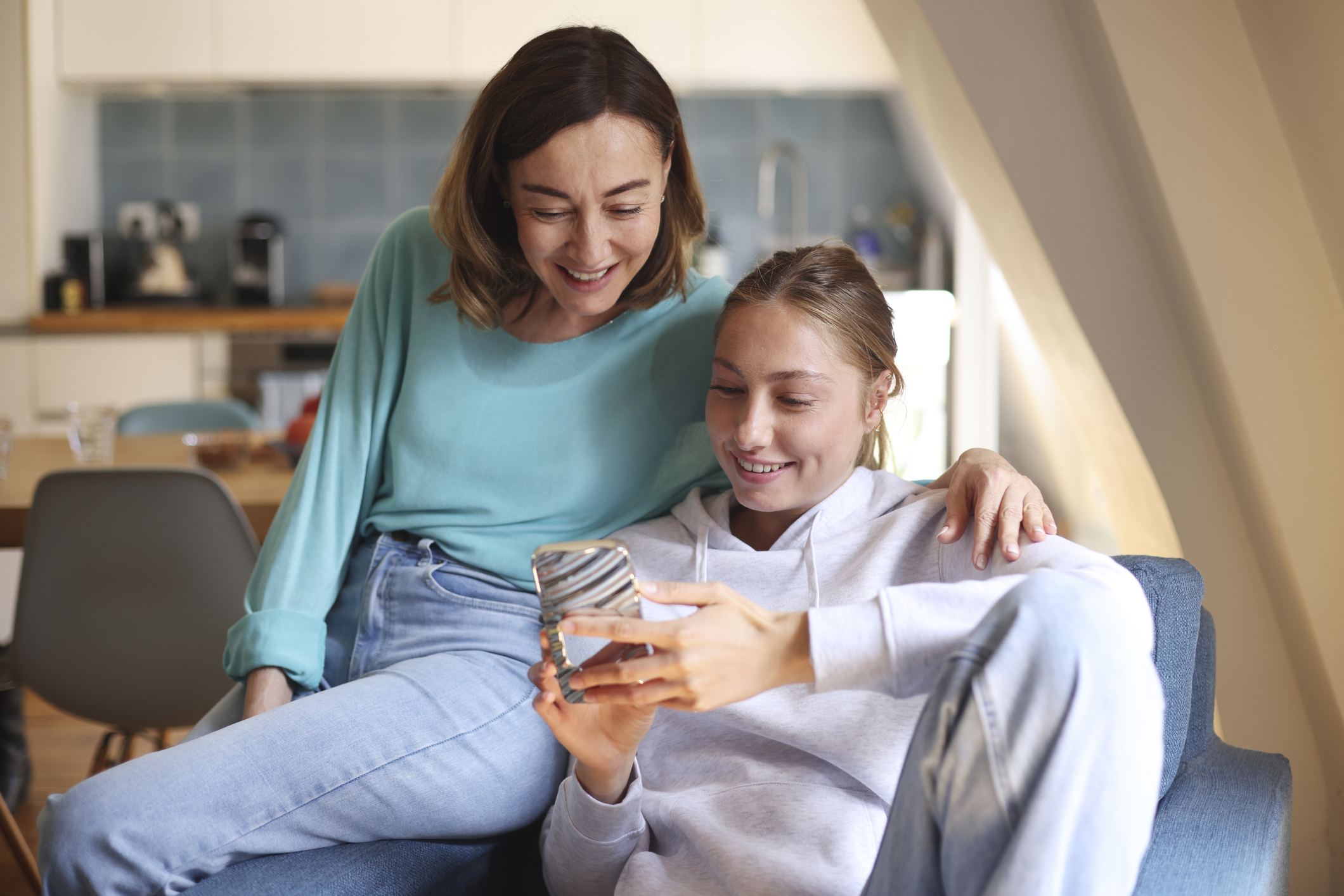 Happy mom and daughter on her phone.