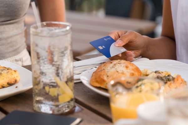 Holding a Magnifi credit card in a restaurant.
