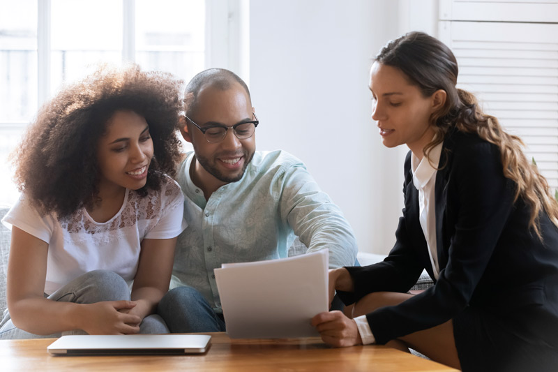 Couple looking at paperwork with mortgage lender.