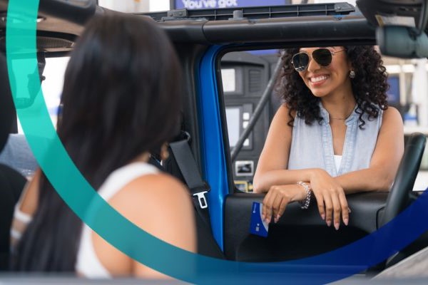 Young woman paying at the gas pump with Magnifi credit card.